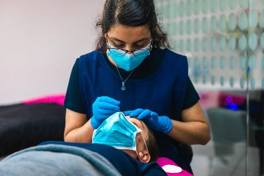 Esthetician conducts eyebrow threading service